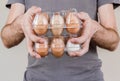 Caucasian man with gray tshirt holding two plastic egg boxes full of chicken eggs Royalty Free Stock Photo
