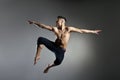 Caucasian man gymnastic leap posture on grey