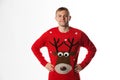 Caucasian man with hand on hips whilst wearing a christmas jumper