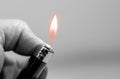 Caucasian man hand holding a black lighter in black and white Royalty Free Stock Photo