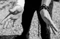 Caucasian man hand in rusty chains , shallow depth of field, conceptual image of crime