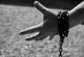 Caucasian man hand in rusty chains , shallow depth of field, conceptual image of crime,slavery