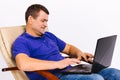 Caucasian man with hearing impairment. Behind a laptop and with a hearing aid, influencer is introduced to work online Royalty Free Stock Photo