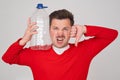 Caucasian man holding empty plastic bottle. Problem with frinking pure water. Royalty Free Stock Photo