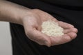 A Caucasian man holds raw long-grain rice in a hand. Royalty Free Stock Photo