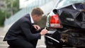 Caucasian man looking crashed auto after car accident, damage repair, insurance Royalty Free Stock Photo