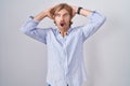 Caucasian man with mustache standing over white background crazy and scared with hands on head, afraid and surprised of shock with Royalty Free Stock Photo