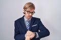 Caucasian man with mustache wearing business clothes checking the time on wrist watch, relaxed and confident Royalty Free Stock Photo