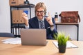 Caucasian man with mustache working at the office doing online shopping smiling with an idea or question pointing finger with Royalty Free Stock Photo