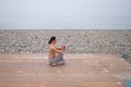 Caucasian man with naked torso practicing wushu on the seashore. Royalty Free Stock Photo