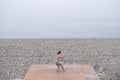 Caucasian man with naked torso practicing wushu on the seashore. Royalty Free Stock Photo