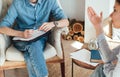 Caucasian man psychologist sitting in a chair at the workplace, listens to the patient and takes notes