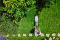 Caucasian man pushing lawn mower for cutting green grass in garden with sunlight at summer season. Aerial view. Housework and Royalty Free Stock Photo