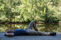 Caucasian man relaxes on a wooden dock by a tranquil woodland pond Royalty Free Stock Photo