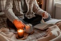 A caucasian man relaxing at home, lighting candle, drinking coffee reading book in bed Royalty Free Stock Photo
