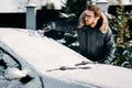 Caucasian man removes snow from vehicle, cleaning snow after blizzard Royalty Free Stock Photo