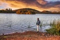 caucasian man at the shore of a lake watching african landscape at sunset Royalty Free Stock Photo