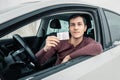 Man shows his driver`s license in the car window immediately after passing the exam or at the request of the traffic