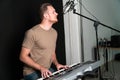 Caucasian man singer-musician playing electronic keyboard in the recording studio Royalty Free Stock Photo