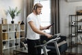 Caucasian man in sport clothes using headset working tablet computer while doing cardio training Royalty Free Stock Photo