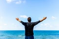 Caucasian man spreading arms,watching ocean. happy man with outstretched arms.rear view beach summer blue sky clouds Royalty Free Stock Photo