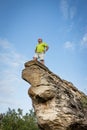 Caucasian man standing on the tip of a high natural sandstone rock formation Royalty Free Stock Photo