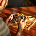 Caucasian man taking pictures of meat steak with his mobile phone. Unrecognizable male food blogger takes a photo of