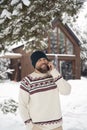 Man talking by mobile phone in front of wooden house in winter Royalty Free Stock Photo