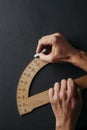 Man uses a wooden protractor Royalty Free Stock Photo