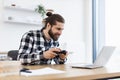 Caucasian man using joystick and laptop sitting at wooden table at kitchen. Royalty Free Stock Photo