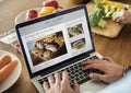 Caucasian man using a laptop in the kitchen searching for recipes Royalty Free Stock Photo