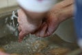 Caucasian man washing hands under tap water. Hygiene procedure concept