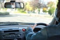 Caucasian man wearing face mask and driving and looking thorough the rear view mirror of the car. Covid-19