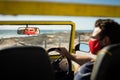 Caucasian man wearing face mask sitting in beach buggy reflected in mirror