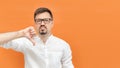 Caucasian man wearing glasses showing dislike with thumbs down at camera and have sadness look. Bad negative sign Royalty Free Stock Photo