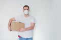 Caucasian man wearing respirator with cardboard box on a white background.