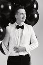 caucasian man in white suit tuxedo with black air balloons Royalty Free Stock Photo