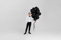 caucasian man in white suit tuxedo with black air balloons Royalty Free Stock Photo