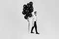 caucasian man in white suit tuxedo with black air balloons Royalty Free Stock Photo