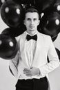 caucasian man in white suit tuxedo with black air balloons Royalty Free Stock Photo