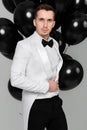 caucasian man in white suit tuxedo with black air balloons Royalty Free Stock Photo