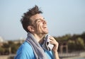 Caucasian man wipes the sweat from his forehead with a towel after exercising