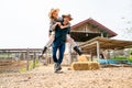 Caucasian man and woman farmer enjoy with woman riding on the back of man and run or walk around the area of their farm with