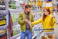 Caucasian married couple in alcohol department in supermarket