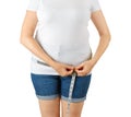 Caucasian mature adult woman begins to gain weight and measures her hips with a measuring tape. Woman dressed in a white T-shirt Royalty Free Stock Photo