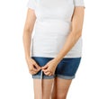 Caucasian mature adult woman begins to gain weight and measures her thigh with a measuring tape. Woman dressed in a white T-shirt Royalty Free Stock Photo