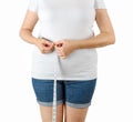 Caucasian mature adult woman begins to gain weight and measures her waist with a measuring tape. Woman dressed in a white T-shirt Royalty Free Stock Photo