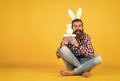 Caucasian mature hipster in buny ears with trendy hairstyle in checkered shirt celebrate easter, copy space, easter joy