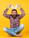 Caucasian mature hipster in buny ears with trendy hairstyle in checkered shirt celebrate easter, easter fun