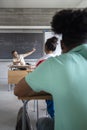 Caucasian mature man teacher with beard pointing blackboard during math class. Vertical image